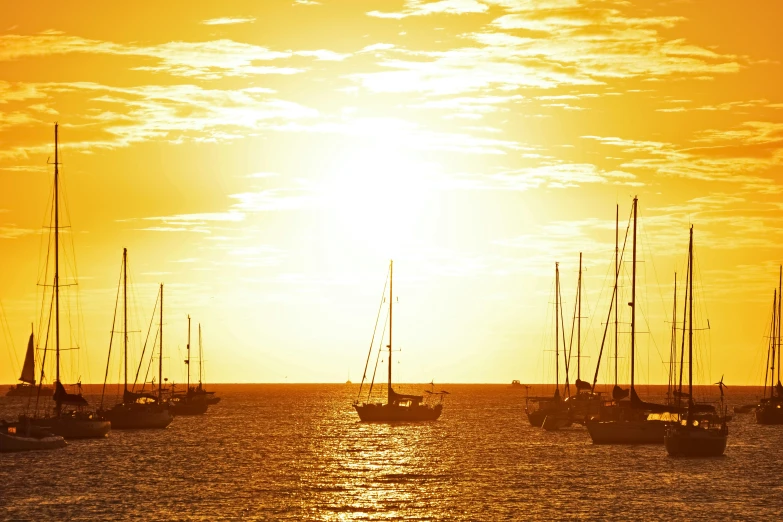 many boats are seen in the water at sunset