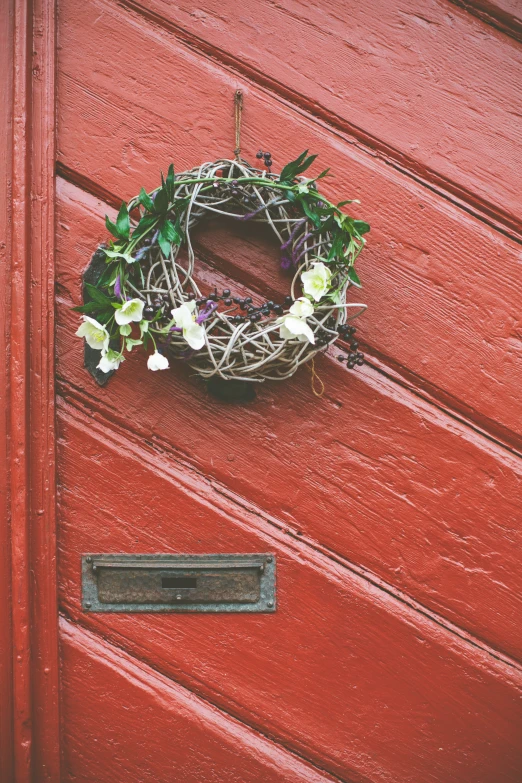 a red door with a wreath hanging on it