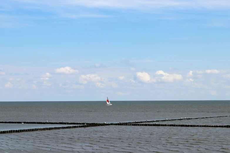 the sail boat is in the distance of the ocean