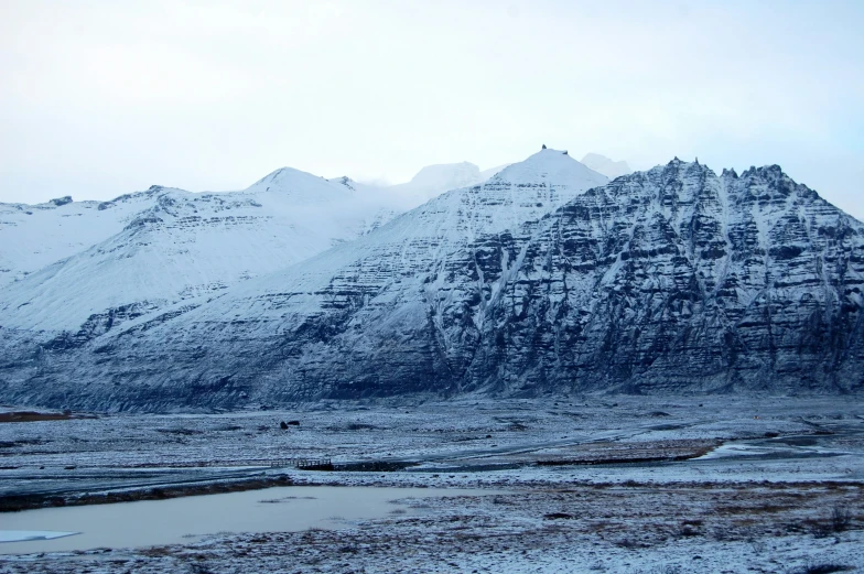 mountains covered with snow near a river in winter