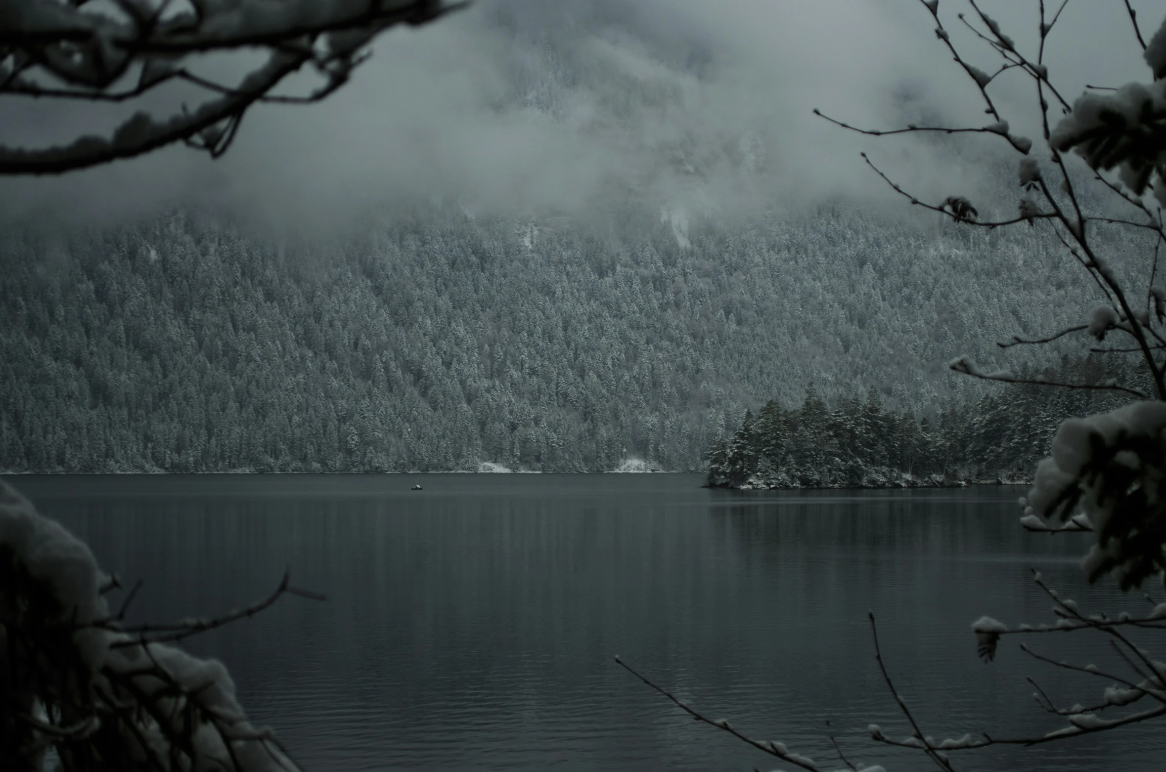 a black and white po of a lake surrounded by snow