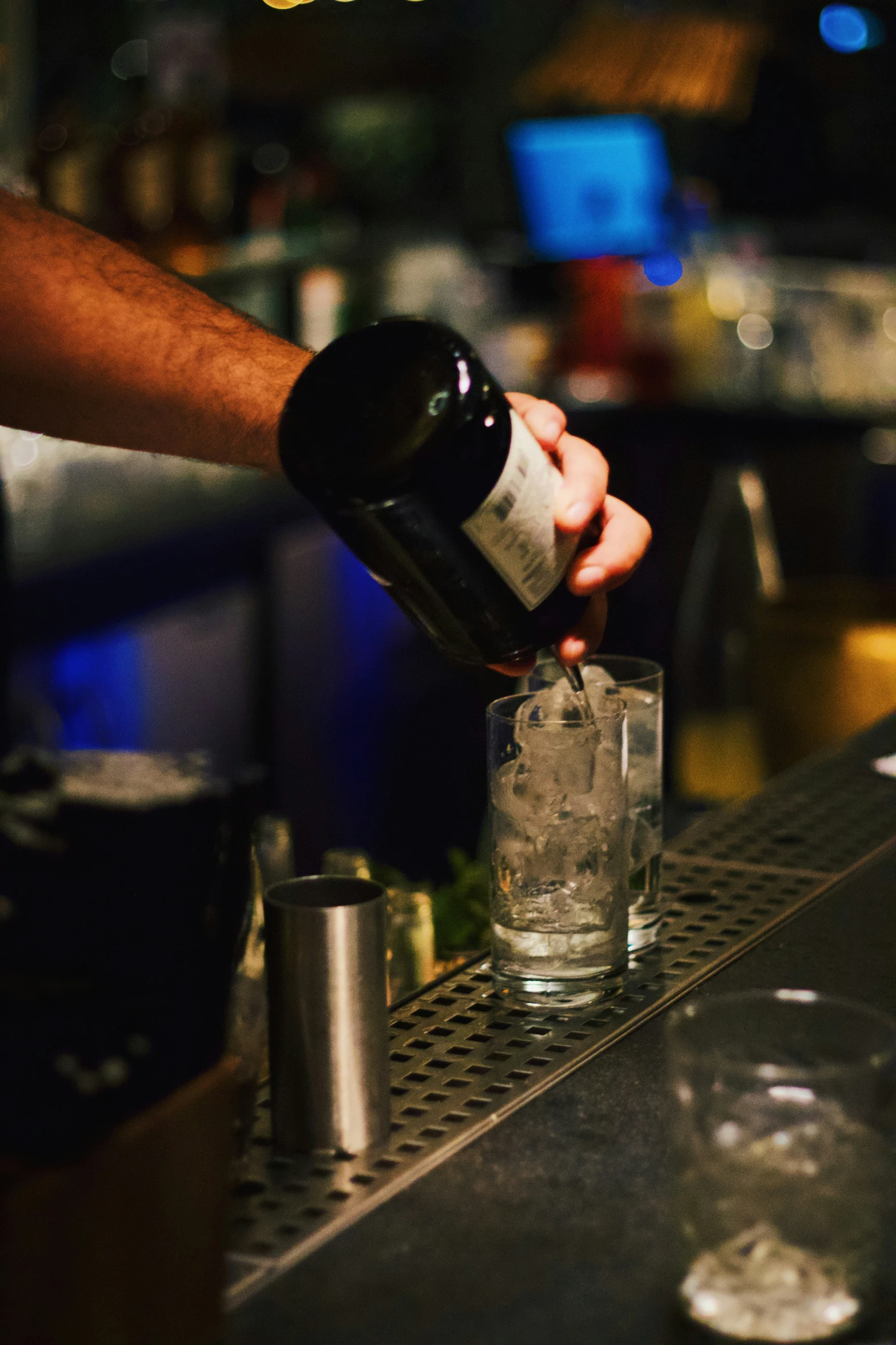 a person pouring vodka into a glass at a bar