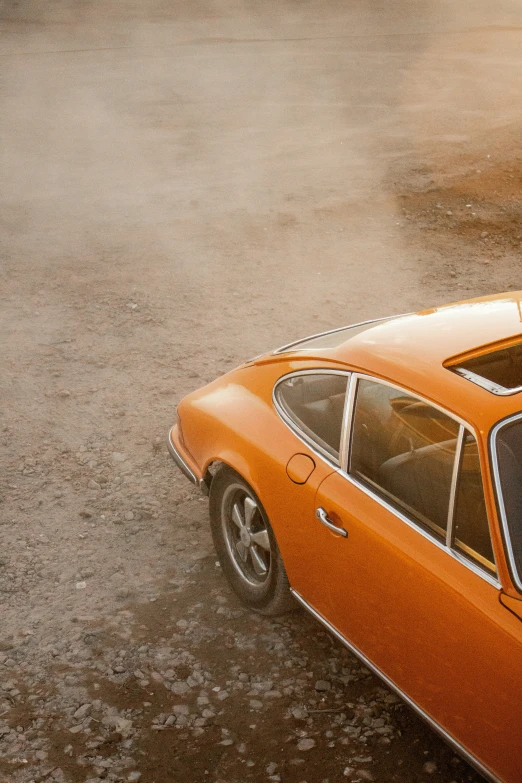 an orange old car in a parking lot