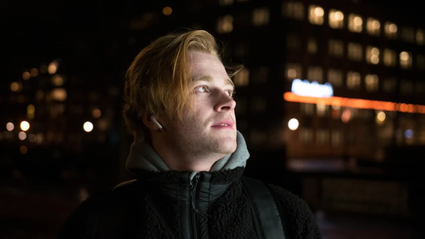 a man with headphones on staring at the sky