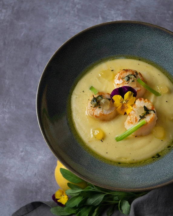 a green bowl filled with soup and topped with shrimp