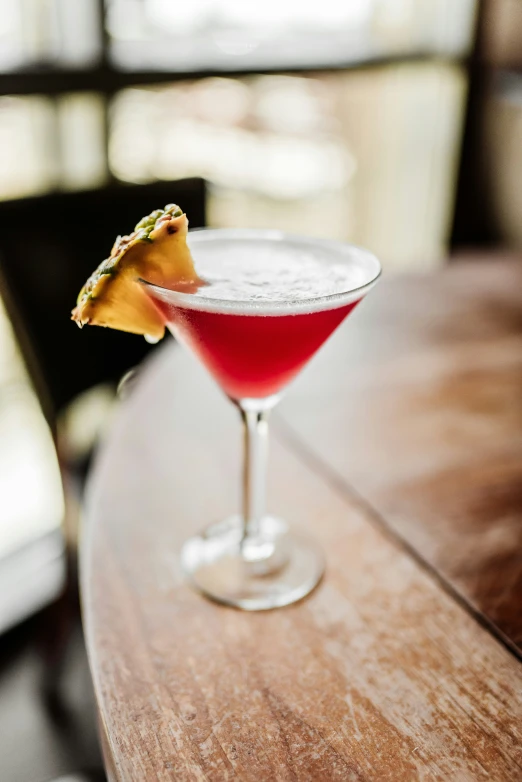 a small cocktail glass filled with a red drink