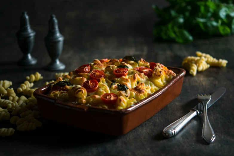 pasta with tomatoes and basil in a red pan