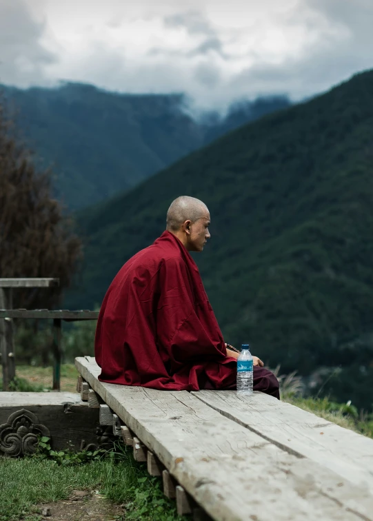 a man with a hat and robe sitting on a bench