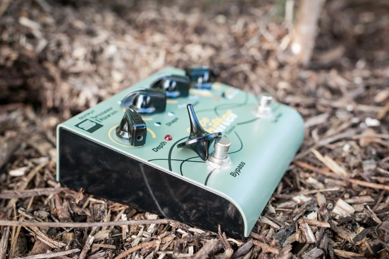 a green and black electronic device on some brown wood