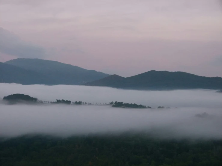 the view from above, looking down at a misty mountain landscape