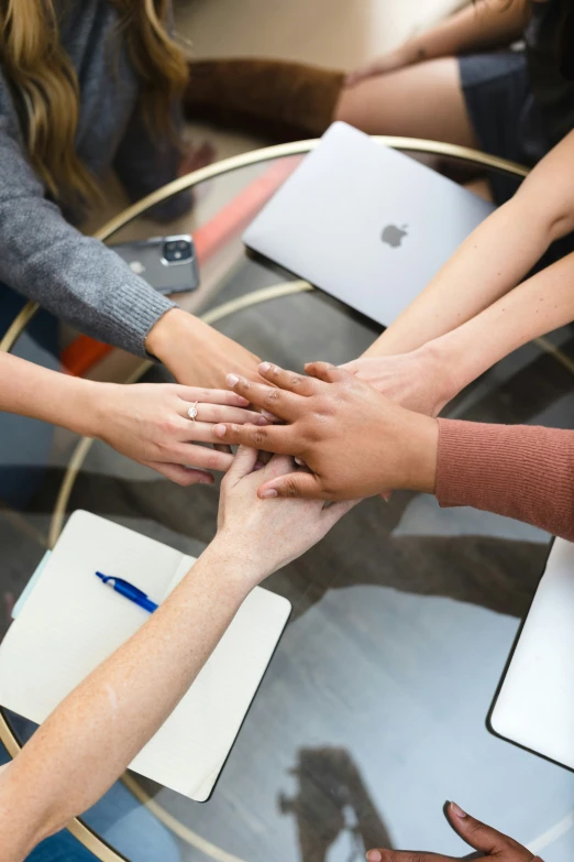 a group of people stack their hands on top of each other