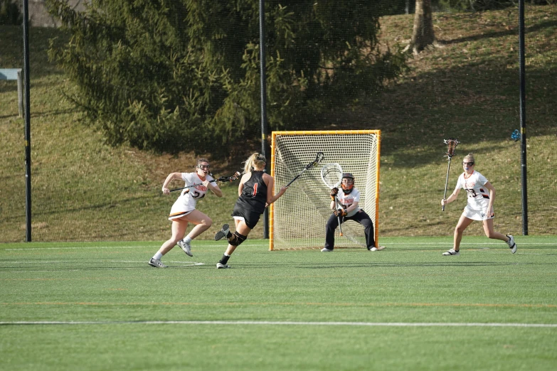 three girls wearing jerseys running toward the soccer goal