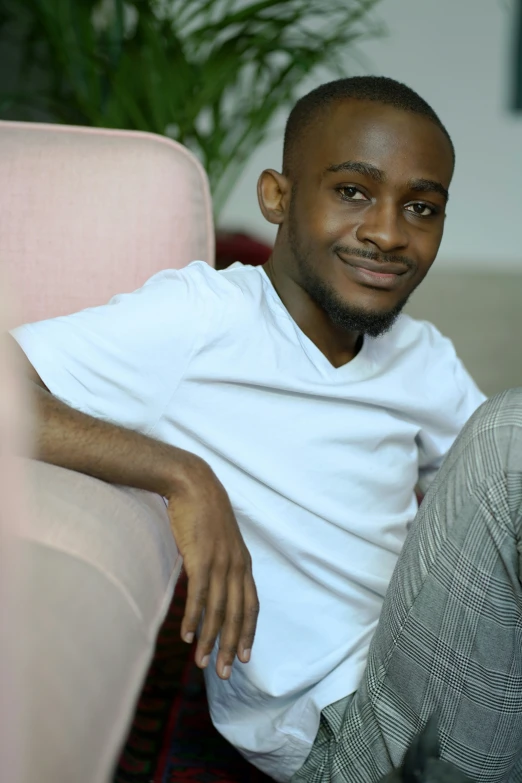 man sitting with his feet propped on the back of a chair