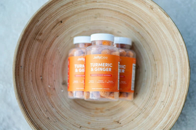 three bottles of turmeric are in a brown bowl