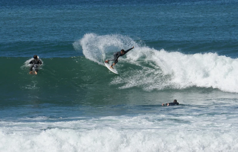 two people riding waves in the ocean on surfboards