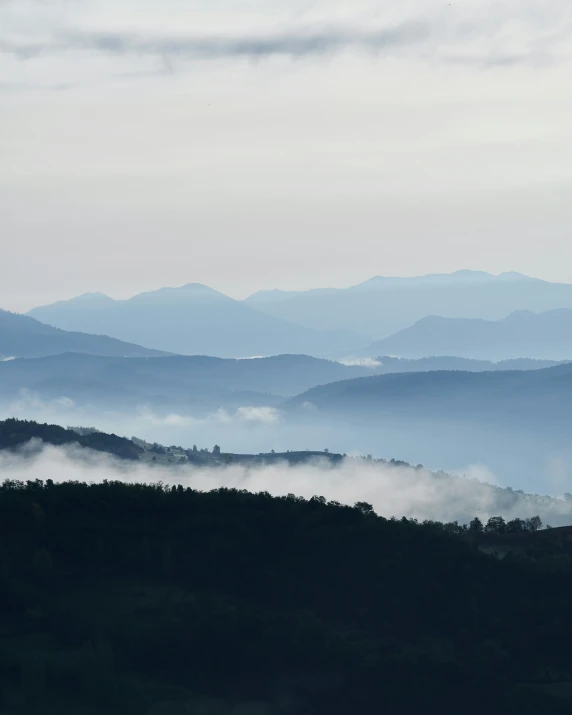 the mountain range is covered with mist from the nearby mountains