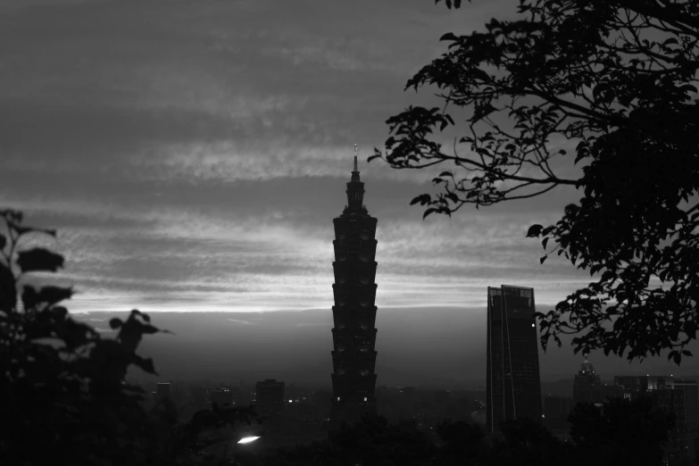 silhouette of large tower with lights on during dusk
