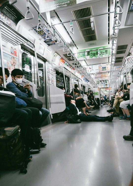 a crowded subway car with passengers seated in seats