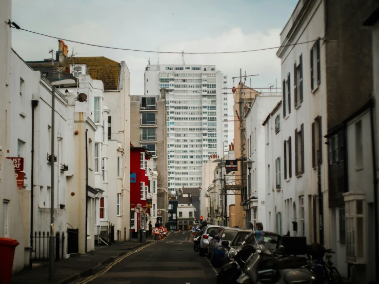 a city street lined with tall buildings and parked cars