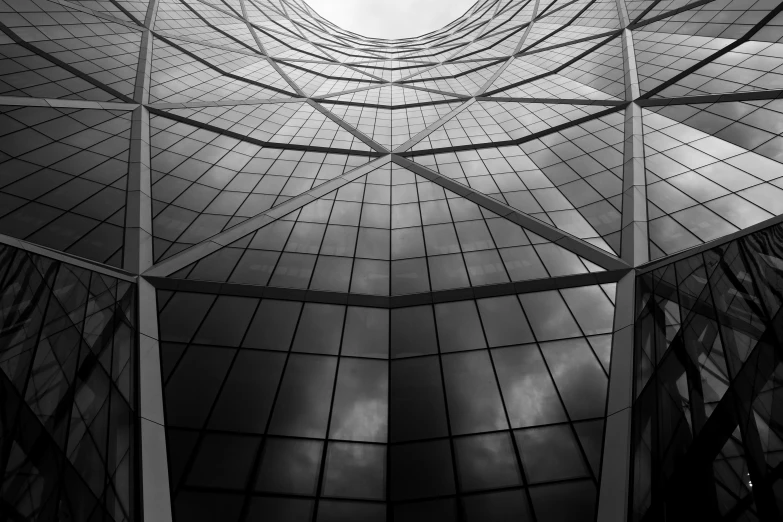 a glass building is shown with the reflection of clouds