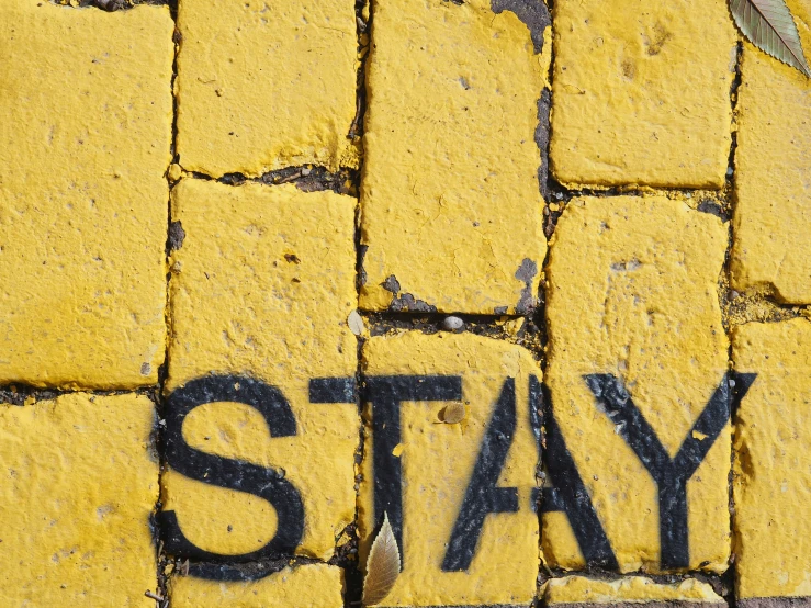 a painted sign on a sidewalk stating stay