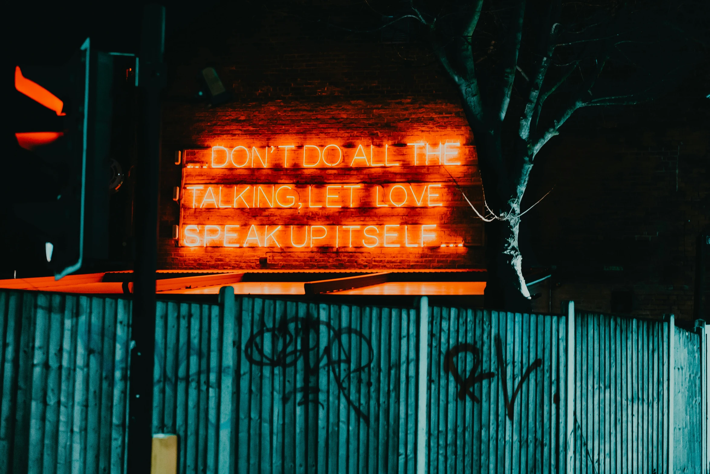 a red lit up sign sitting on the side of a building