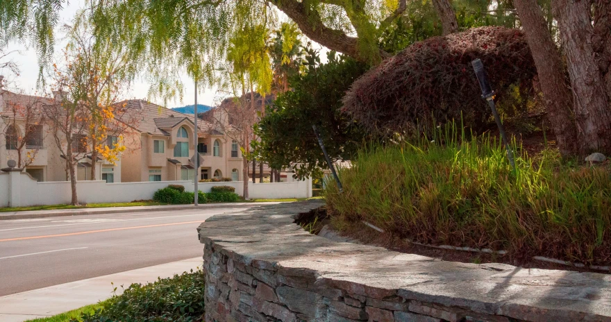 a street side walk lined with grass and trees