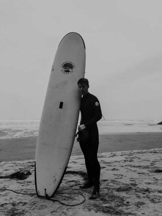 a person standing on the beach holding a surfboard