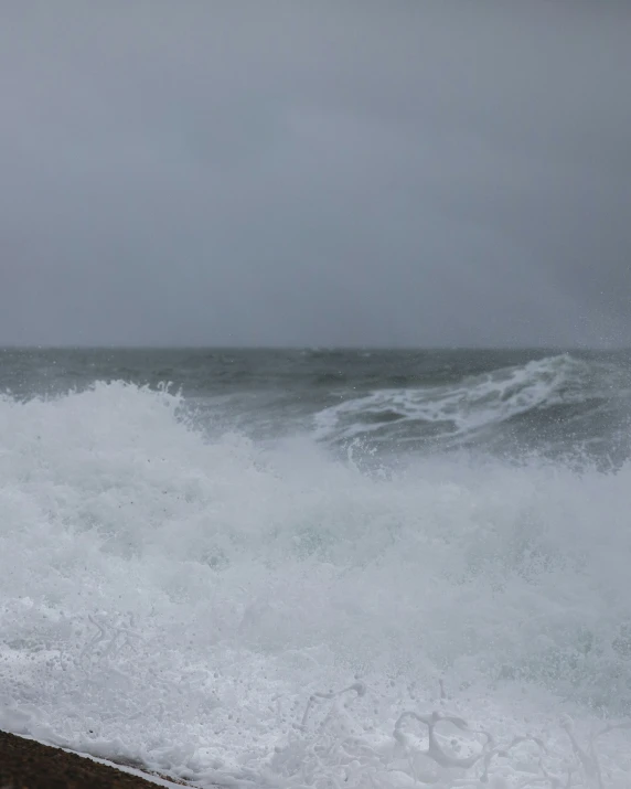 two surfers walk in front of an ocean wave