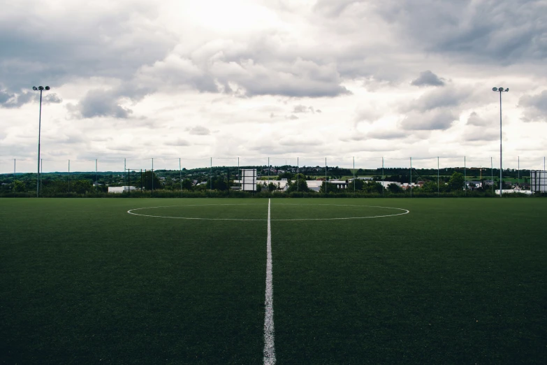 a cloudy sky over a soccer field in a town