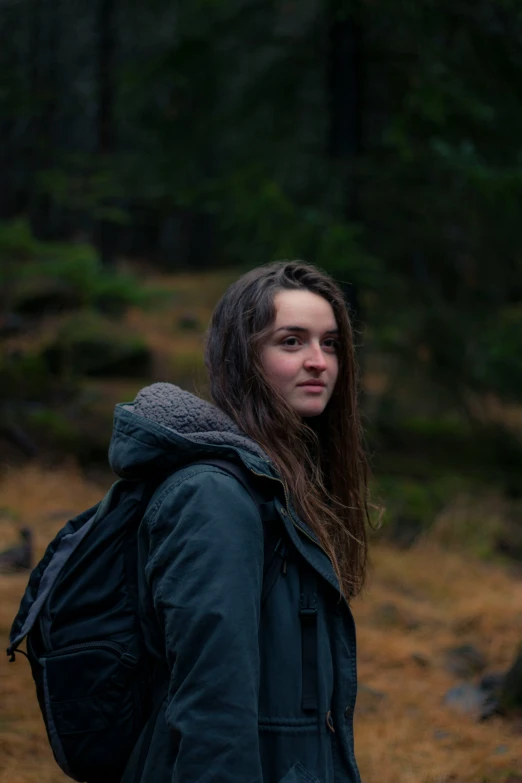 a woman with long hair walking in the woods