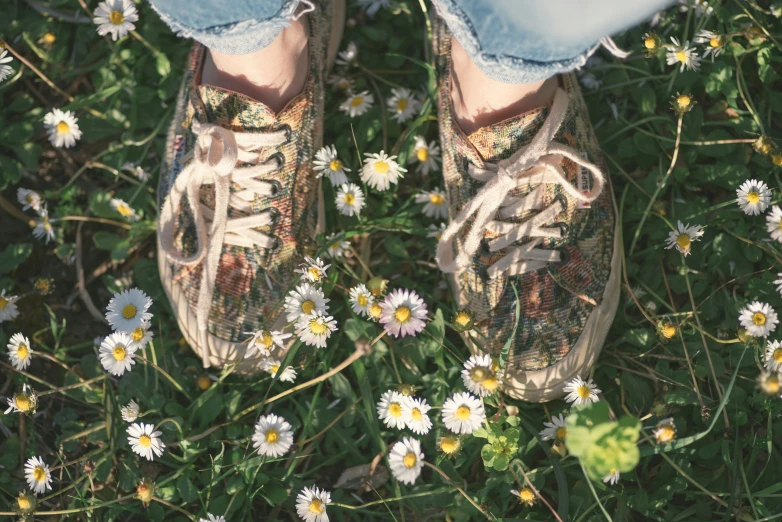 someone wearing some type of sneaker with flowers all over them