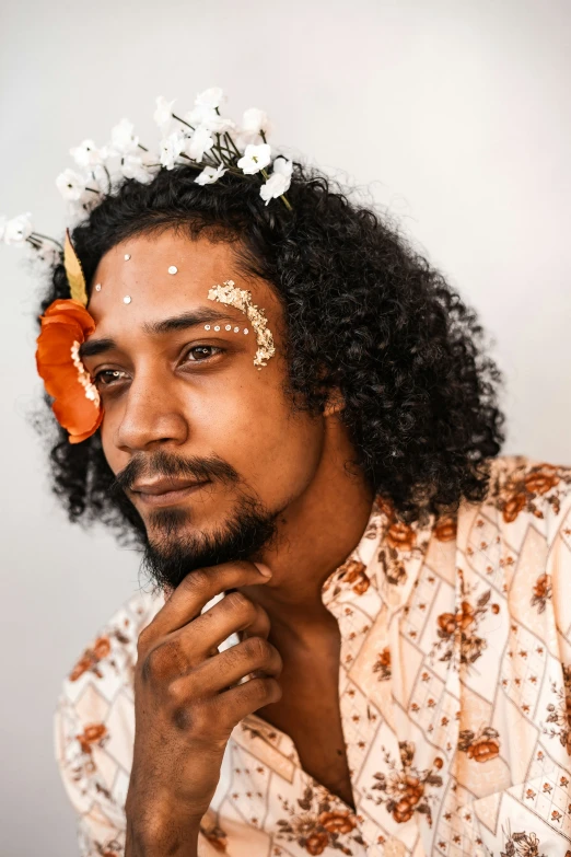 a man in a flower crown looking away from the camera