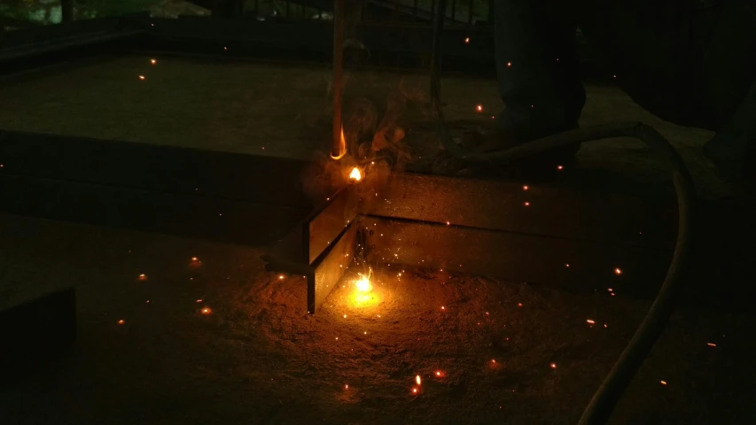 a person lights a fire with sparkles in the dark