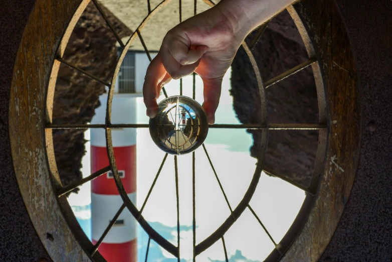 a person holding a coin in front of an old window