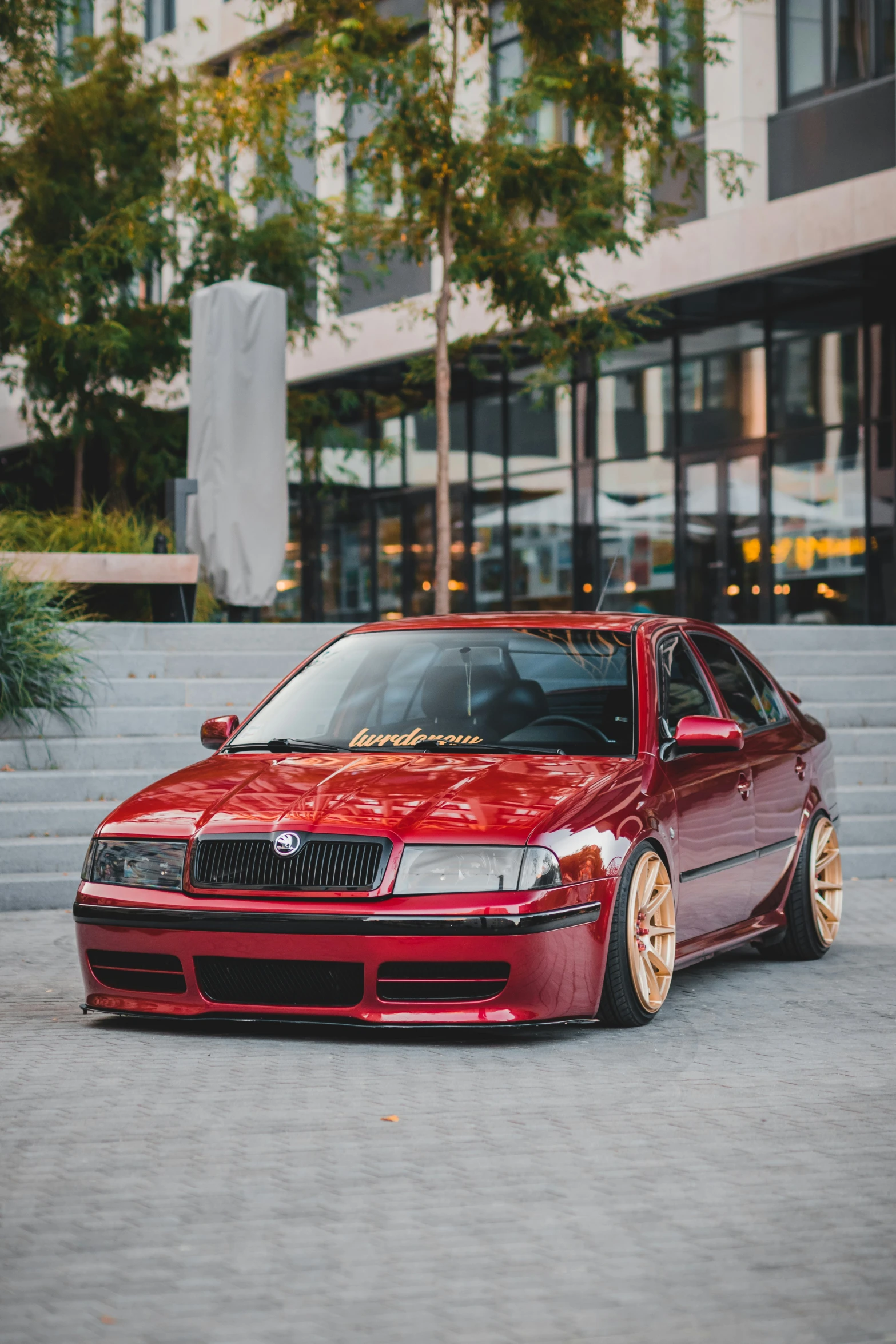 a red car sits parked outside some building