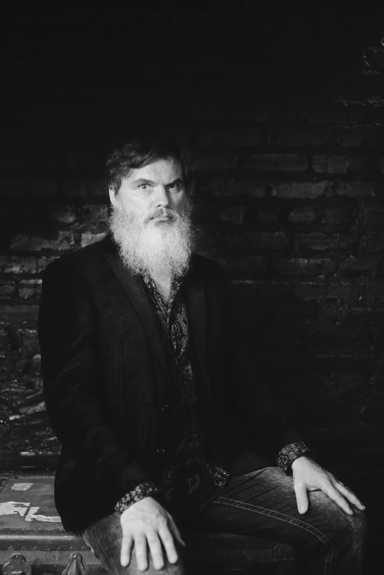 a man with long white beard sitting on a chair