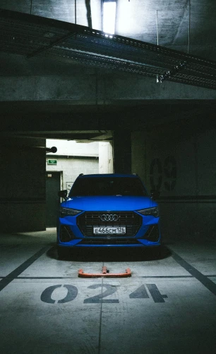 a blue car is sitting in a dimly lit building