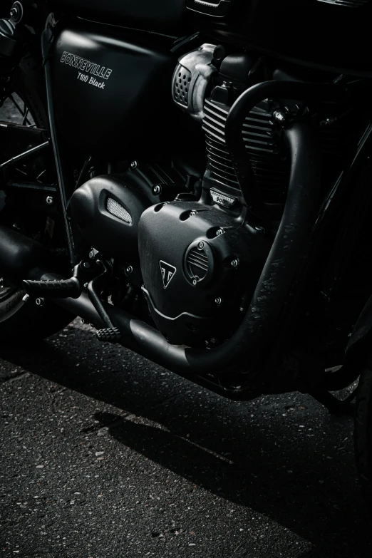 a black motorcycle parked in the dark in front of a building