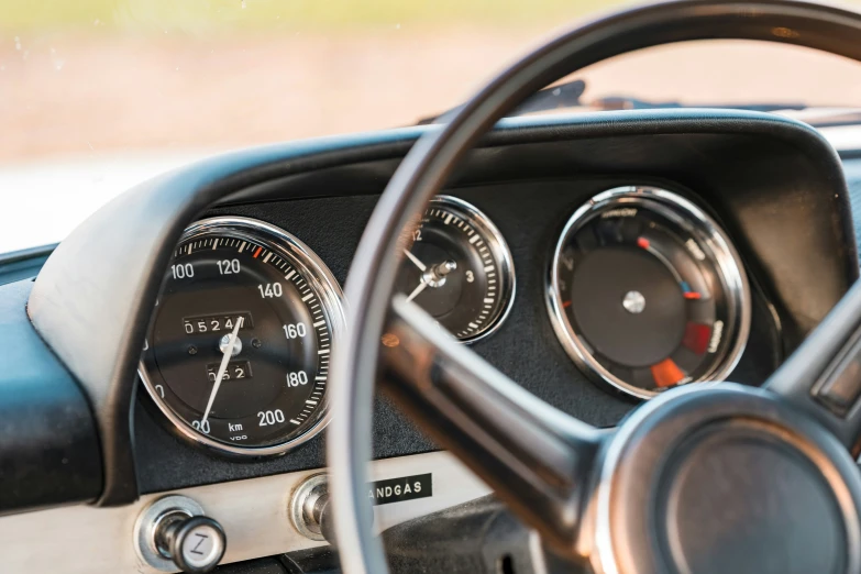 the dashboard of an old style car showing various meters