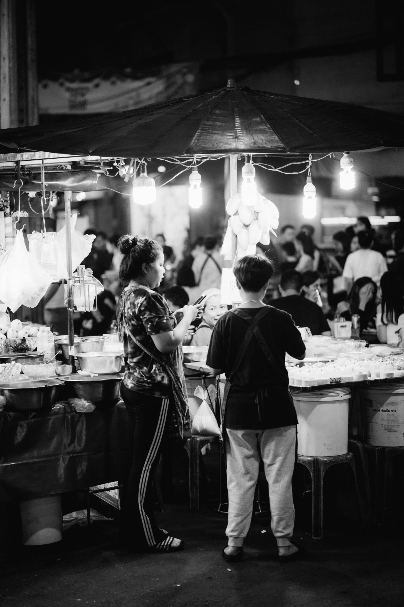 two people stand in front of a market stall