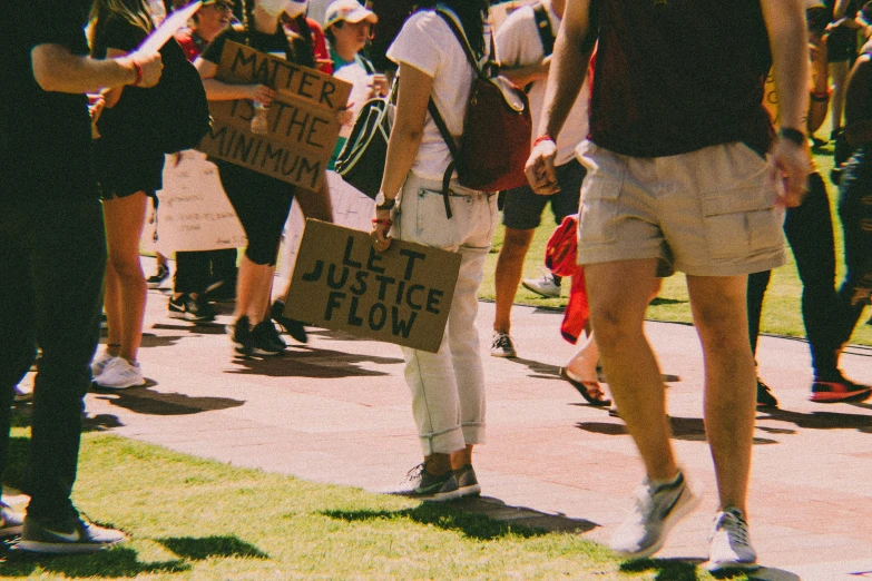 people are marching on the lawn with many signs