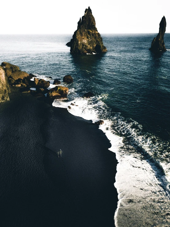 two rocks on an ocean side in the middle of the day