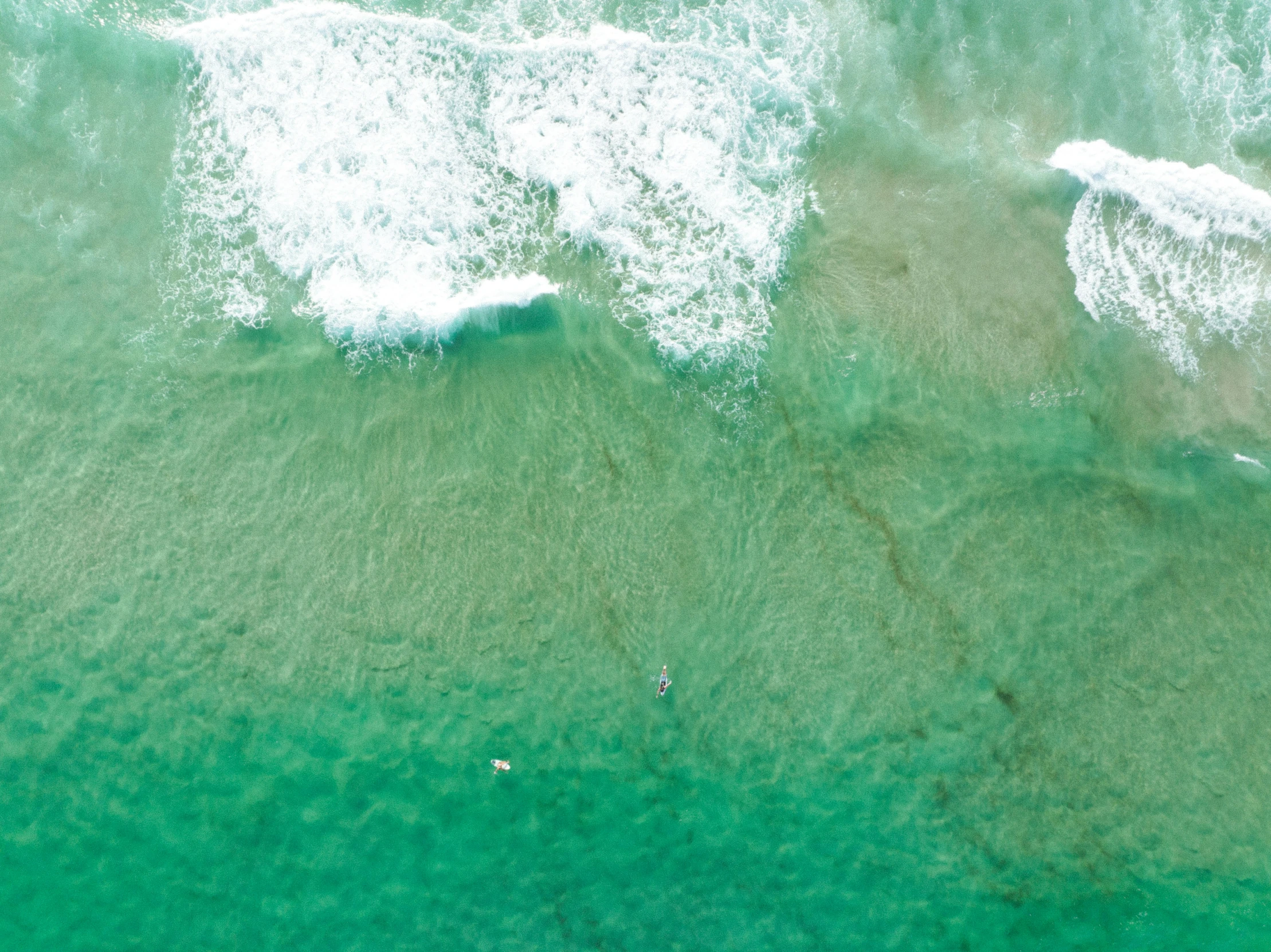 surfers on their boards riding the waves in the ocean