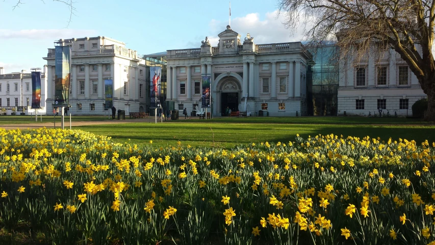 a building with flowers and flags near by