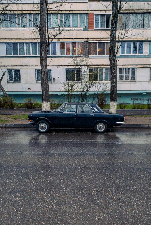 the classic car is parked in front of an old building