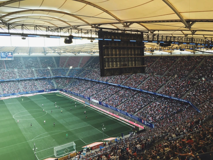 large crowd in a soccer stadium sitting on top of a field