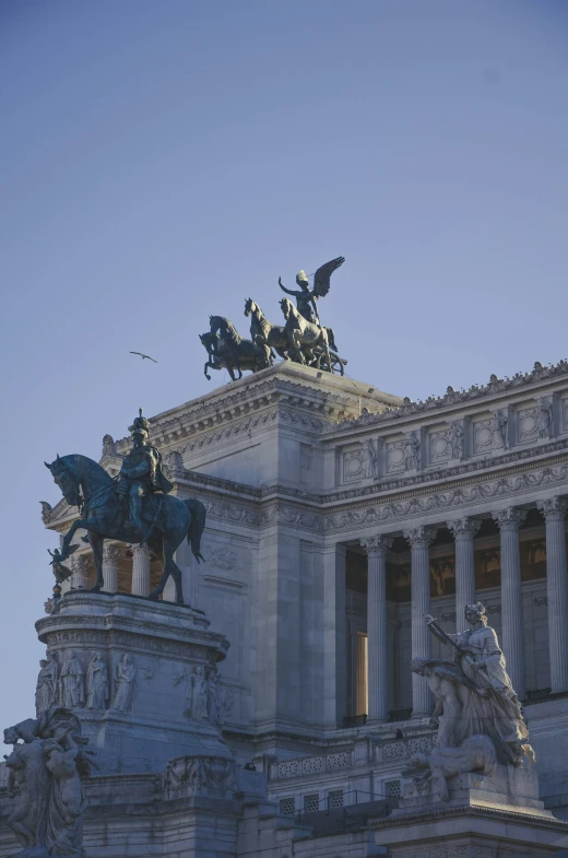 a statue sits on top of a tall building