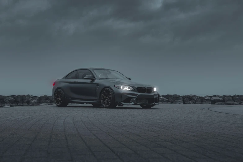 a gray bmw is parked on a gravel road