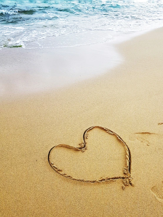 a heart shaped in the sand of a beach